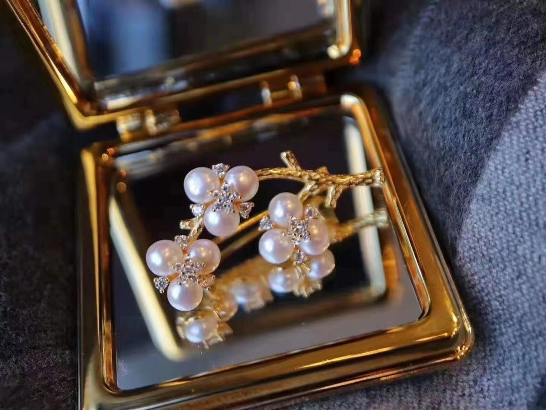 Gold-plated brooch inspired by Chinese plum blossom design with white freshwater pearls, symbolizing elegance and tradition.