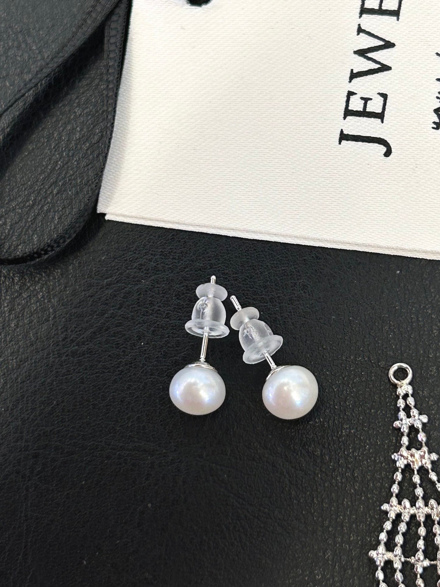 Asymmetric tassel earrings with 7–8mm freshwater pearls and sterling silver posts, featuring a dewdrop-inspired flowing design.