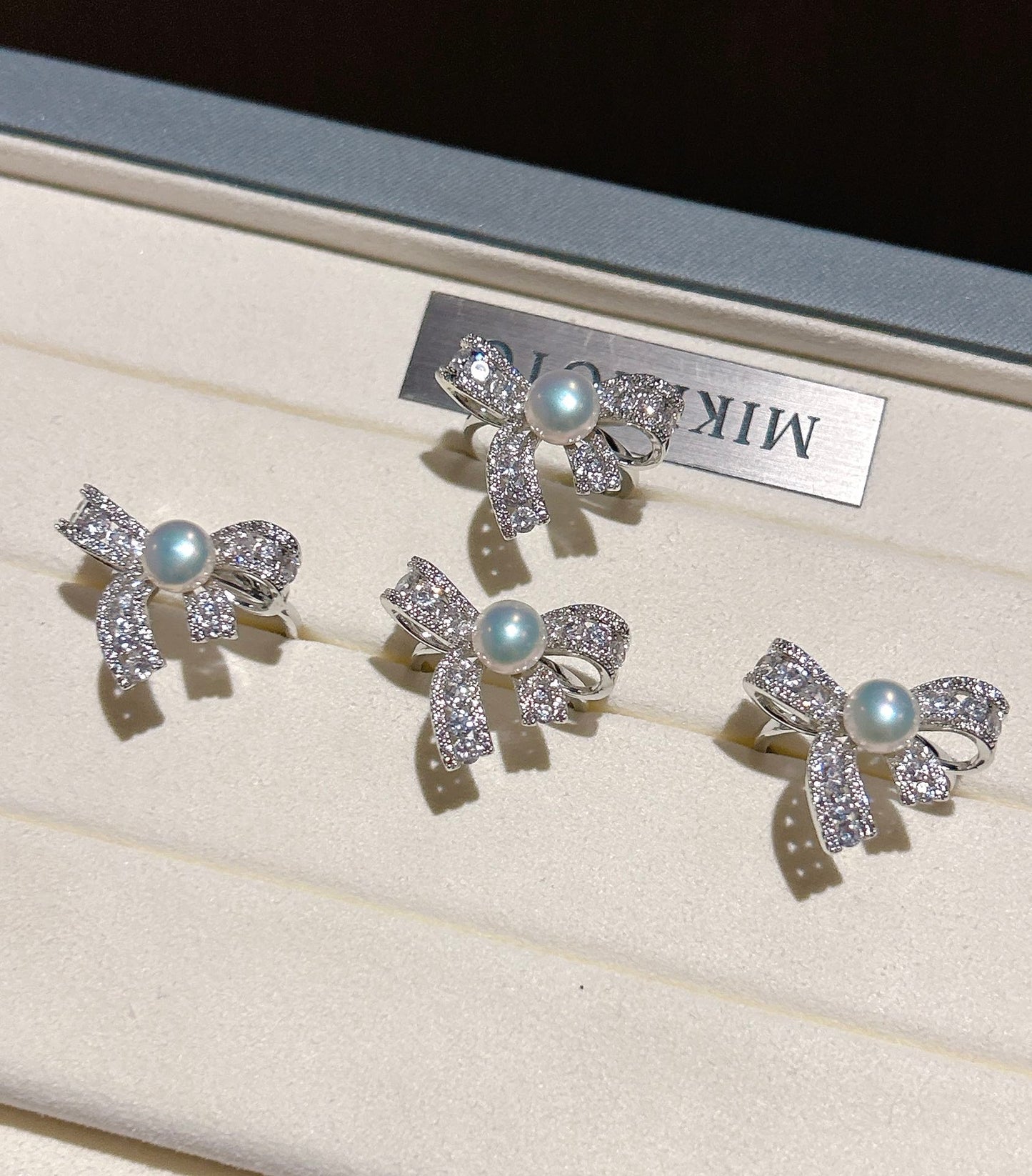 Elegant butterfly-shaped ring with zircon inlay and freshwater pearl on an adjustable gold band.