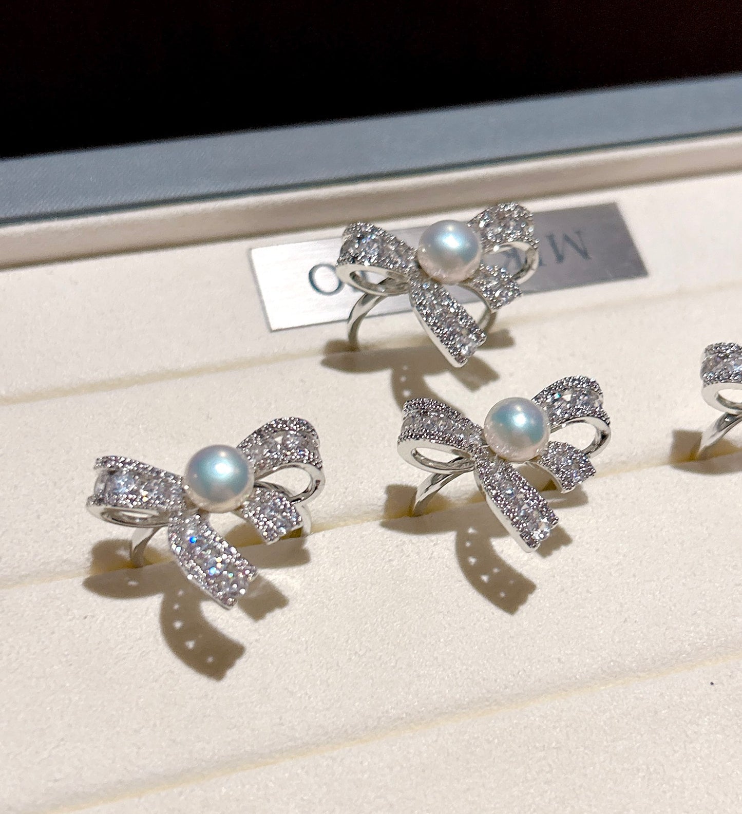 Elegant butterfly-shaped ring with zircon inlay and freshwater pearl on an adjustable gold band.