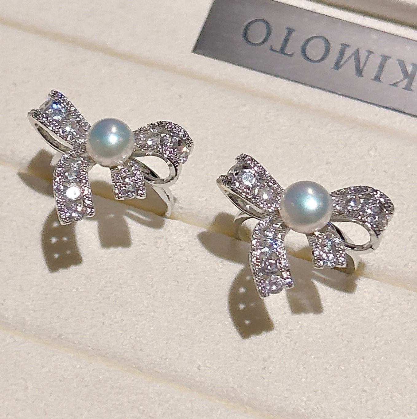 Elegant butterfly-shaped ring with zircon inlay and freshwater pearl on an adjustable gold band.