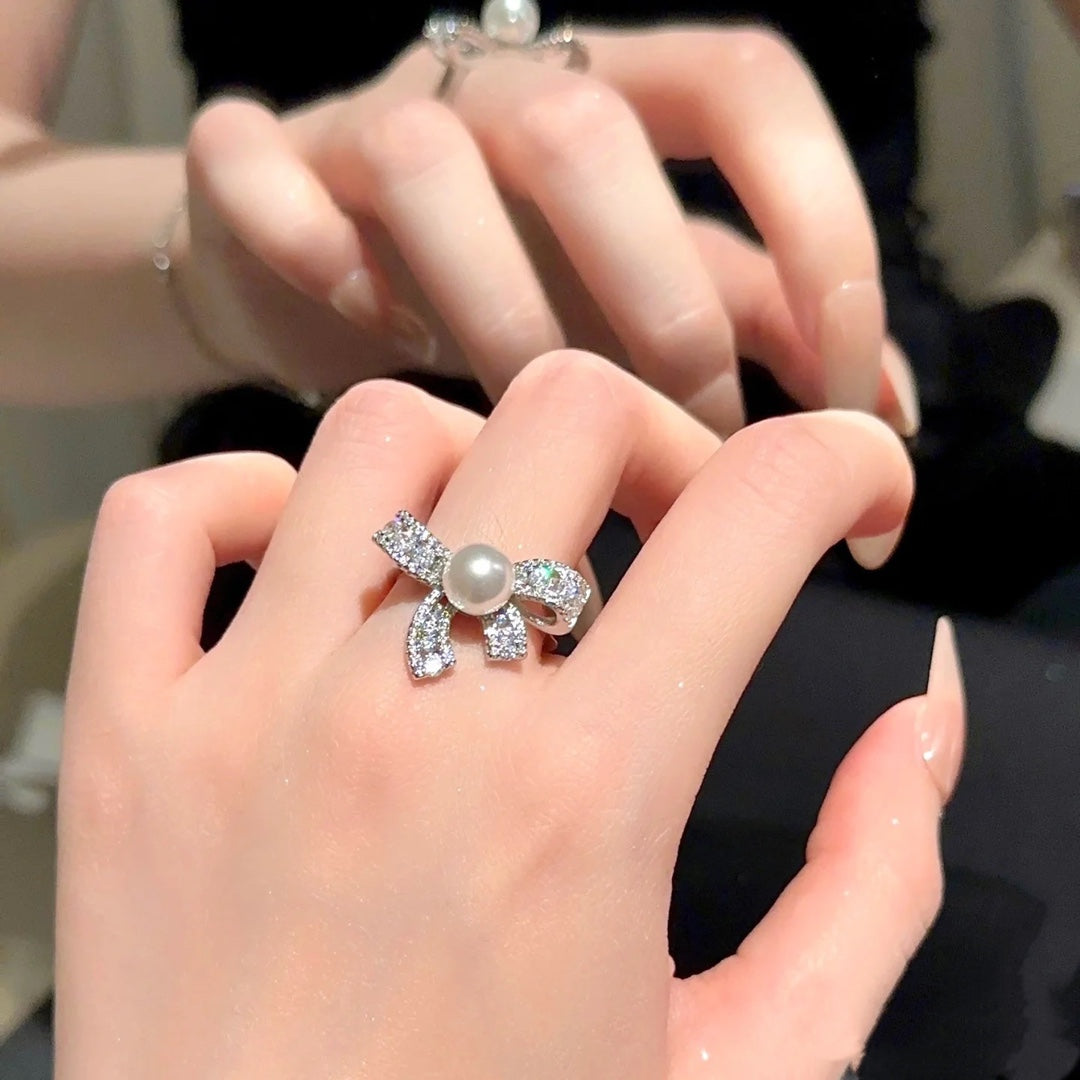 Elegant butterfly-shaped ring with zircon inlay and freshwater pearl on an adjustable gold band.