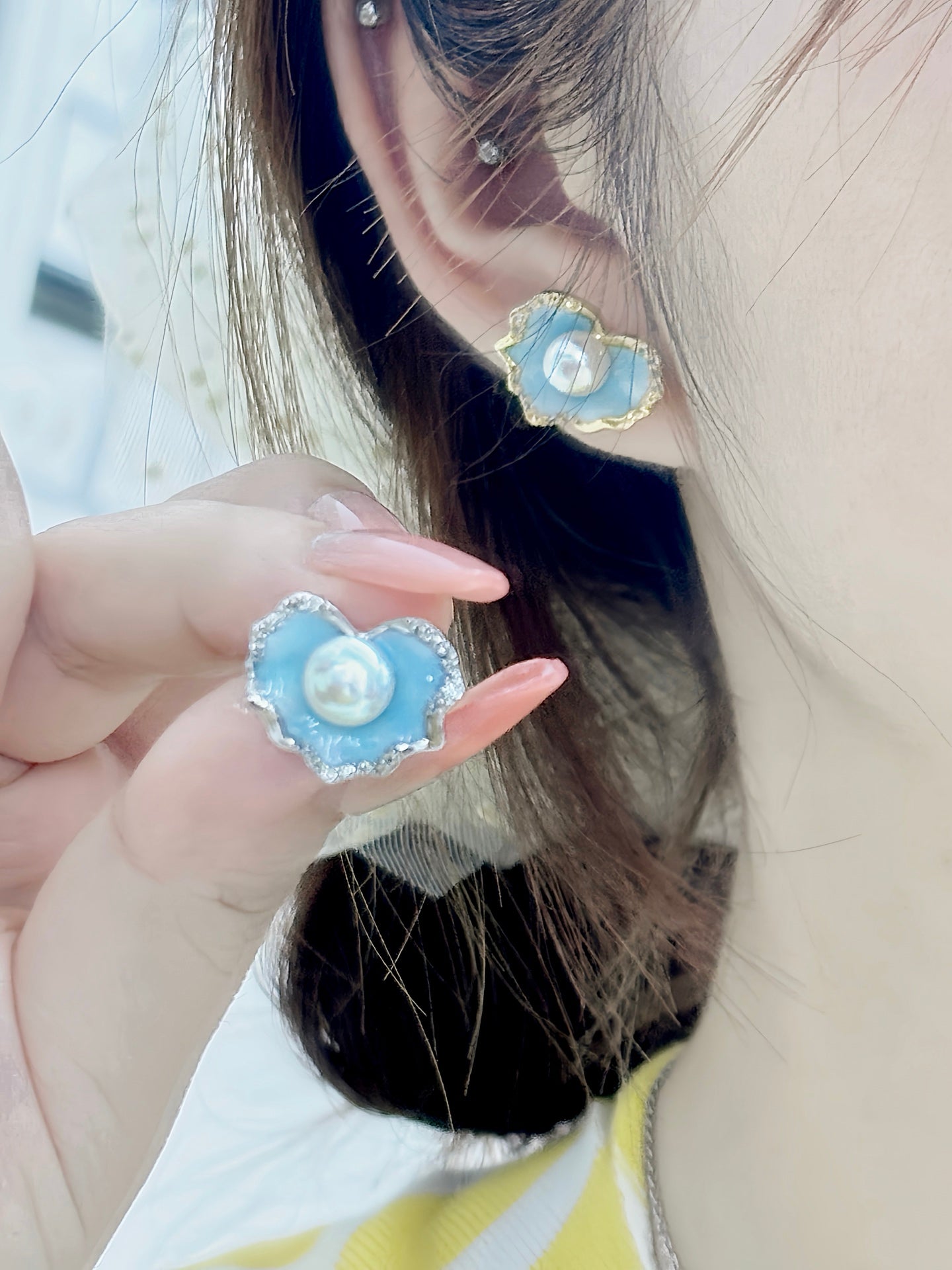 A pair of glacier blue enamel stud earrings featuring 8mm natural freshwater pearls and sterling silver posts.