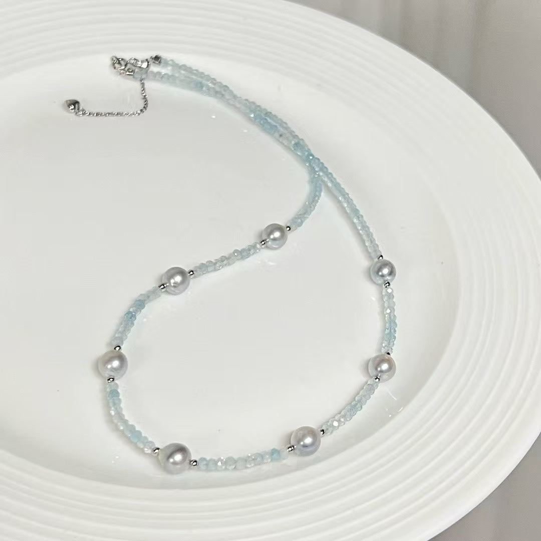 Sterling silver necklace featuring aquamarine stones and 6–7mm grey Akoya baroque pearls, elegant ocean-inspired jewelry.