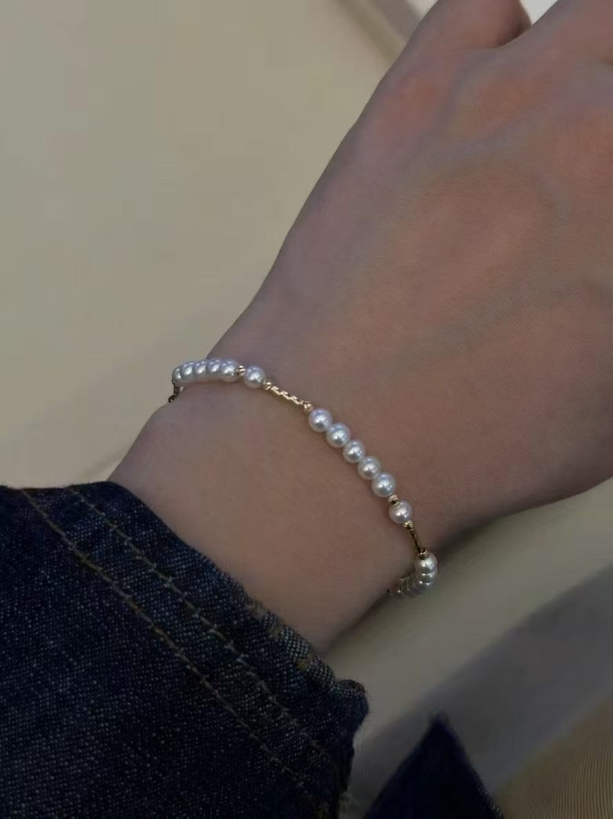 Minimalist bracelet with 3–4mm freshwater baby pearls and 14k gold-plated adjustable chain, delicate and elegant design.