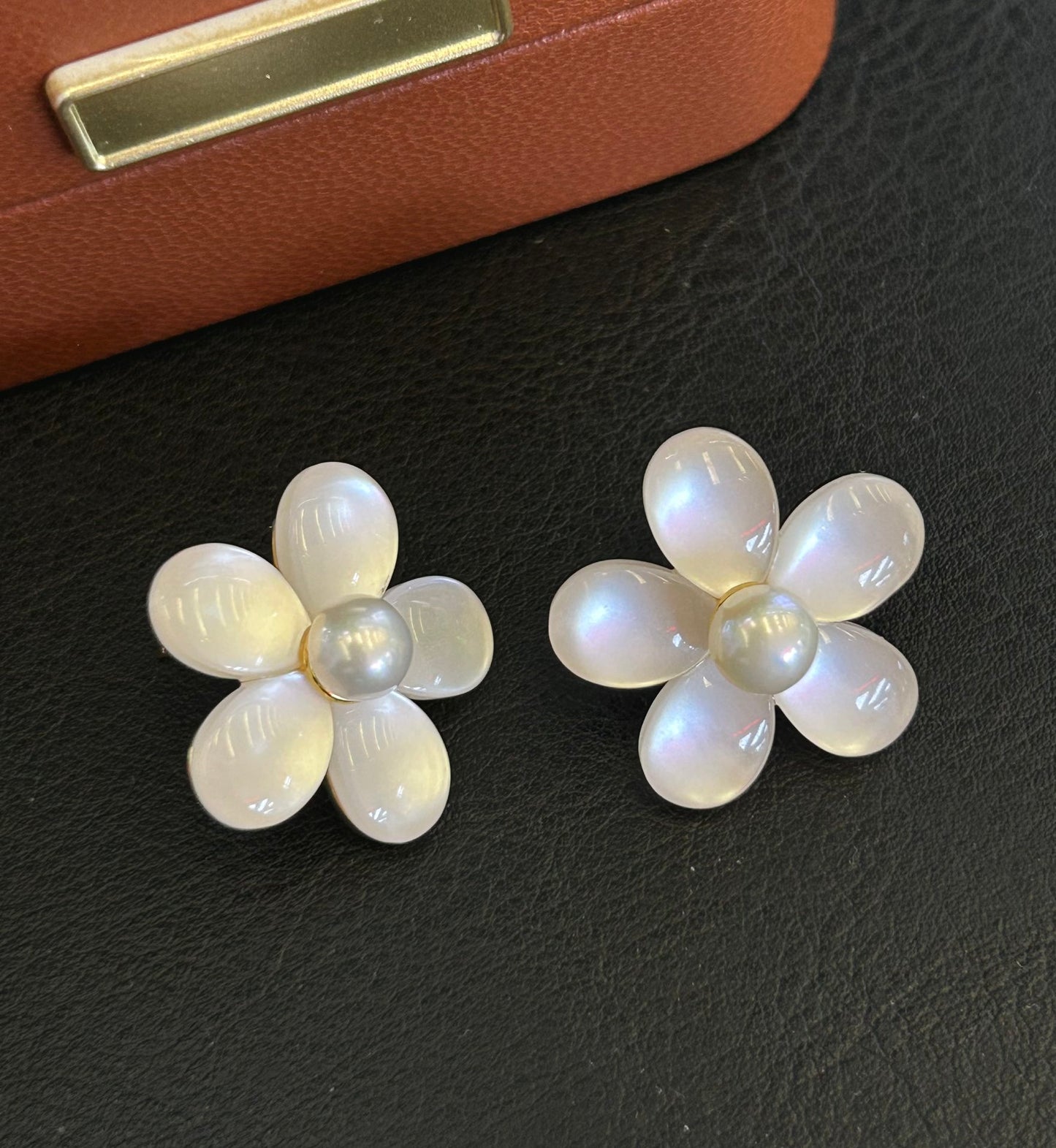 Elegant pearl and cat’s eye floral stud earrings with sterling silver posts.