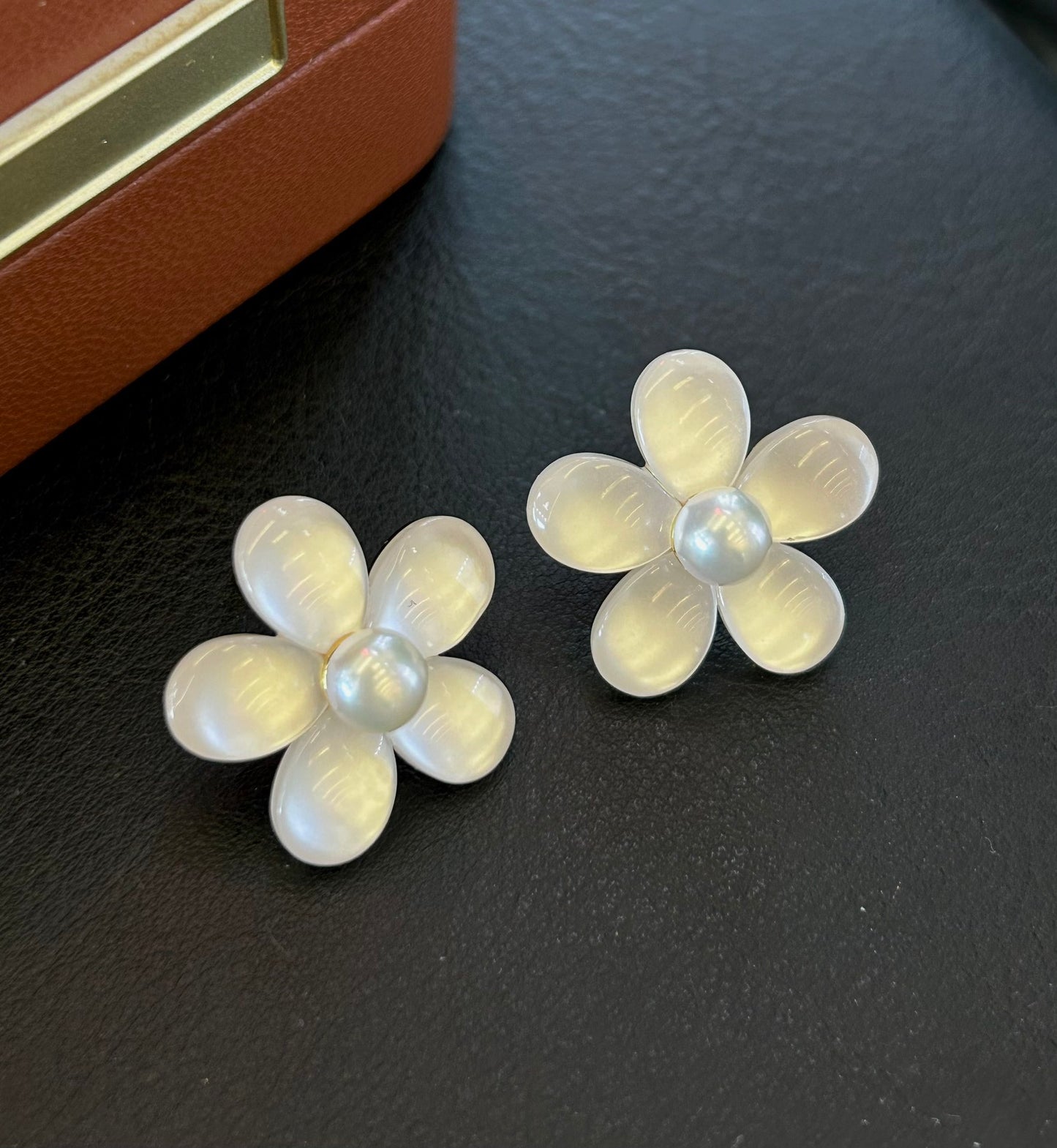 Elegant pearl and cat’s eye floral stud earrings with sterling silver posts.