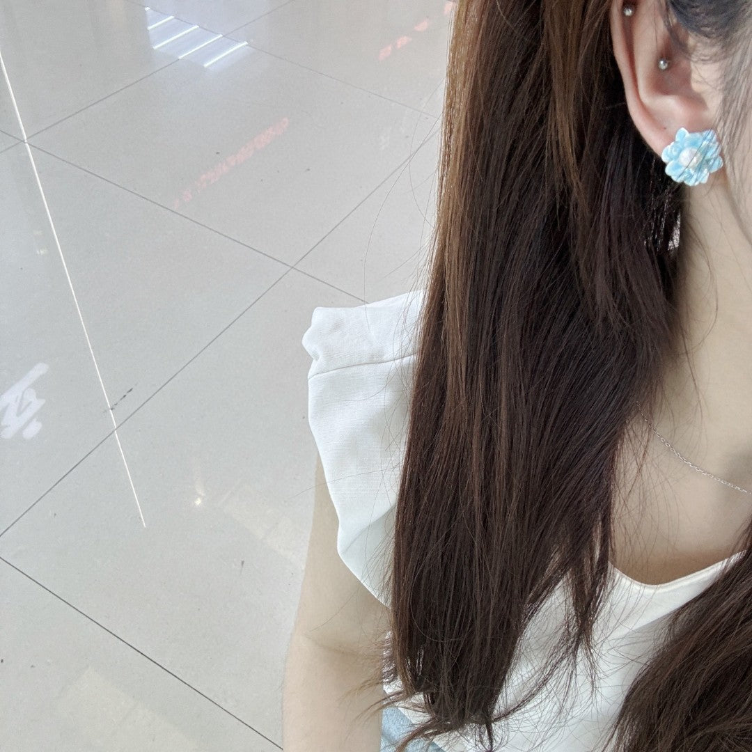 Ice blue floral pearl stud earrings with freshwater pearls and silver posts.