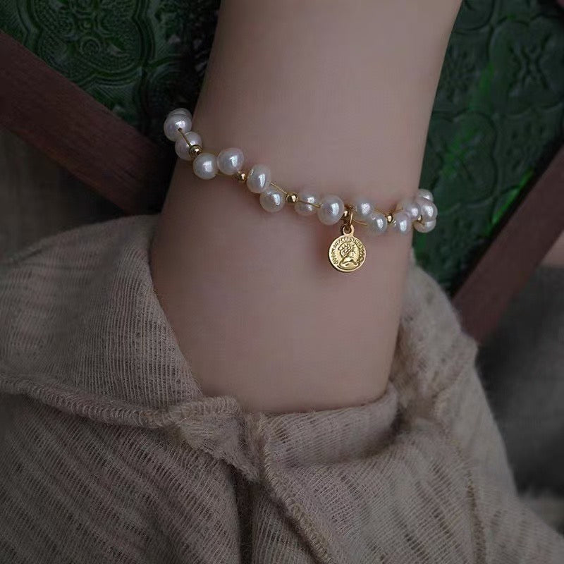 Minimalist freshwater pearl bracelet with round charm and adjustable Japanese woven cord.