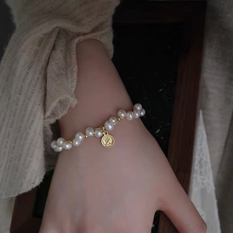 Minimalist freshwater pearl bracelet with round charm and adjustable Japanese woven cord.