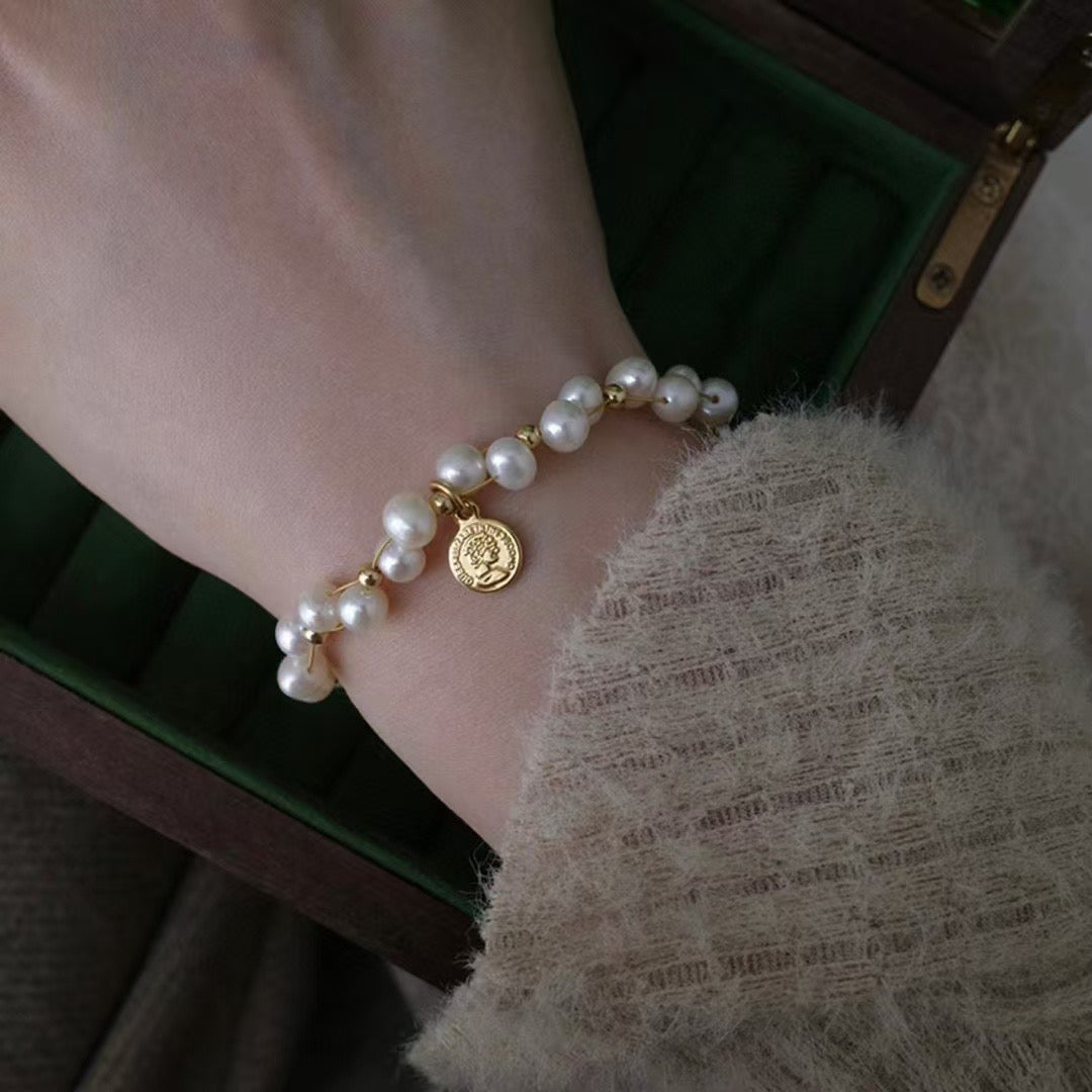 Minimalist freshwater pearl bracelet with round charm and adjustable Japanese woven cord.