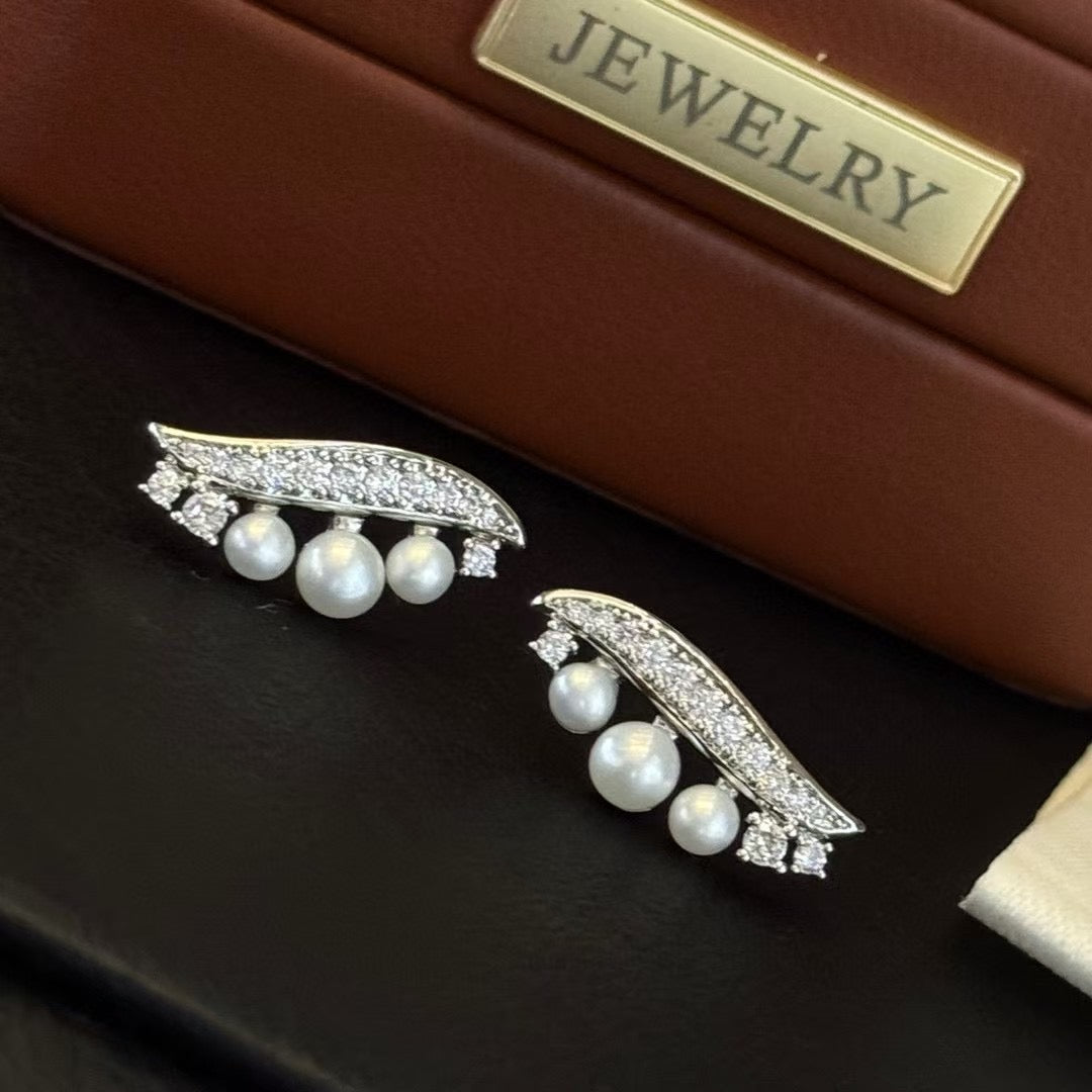 Willow leaf-inspired silver earrings with freshwater pearl accents