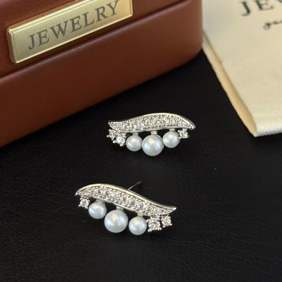 Willow leaf-inspired silver earrings with freshwater pearl accents
