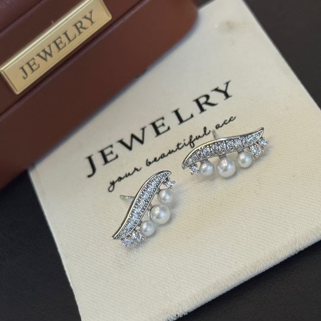 Willow leaf-inspired silver earrings with freshwater pearl accents