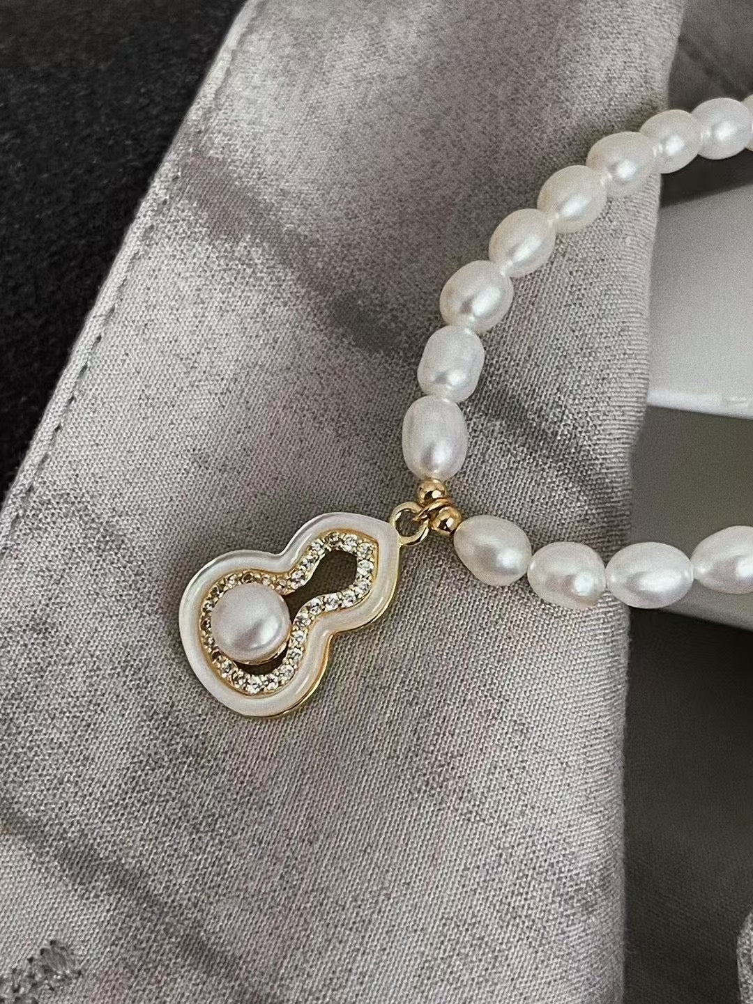 Fúlù pearl necklace with mother-of-pearl and zircon centerpiece, strung with freshwater pearls