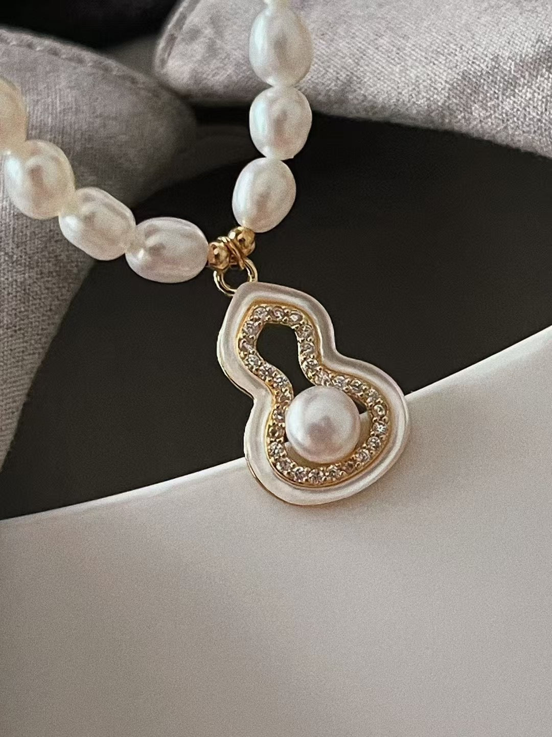 Fúlù pearl necklace with mother-of-pearl and zircon centerpiece, strung with freshwater pearls