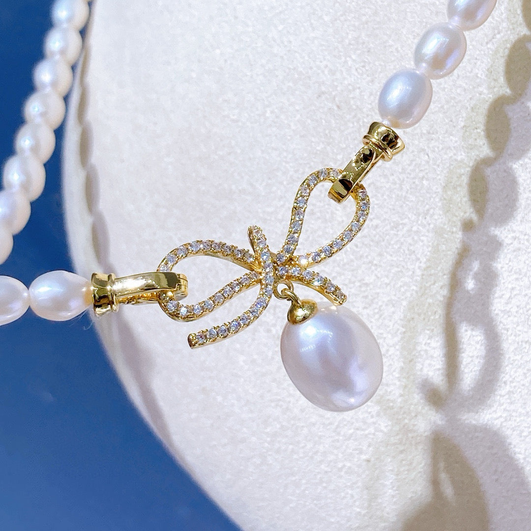 Bow-tie design pearl necklace with freshwater pearls and gold-plated chain