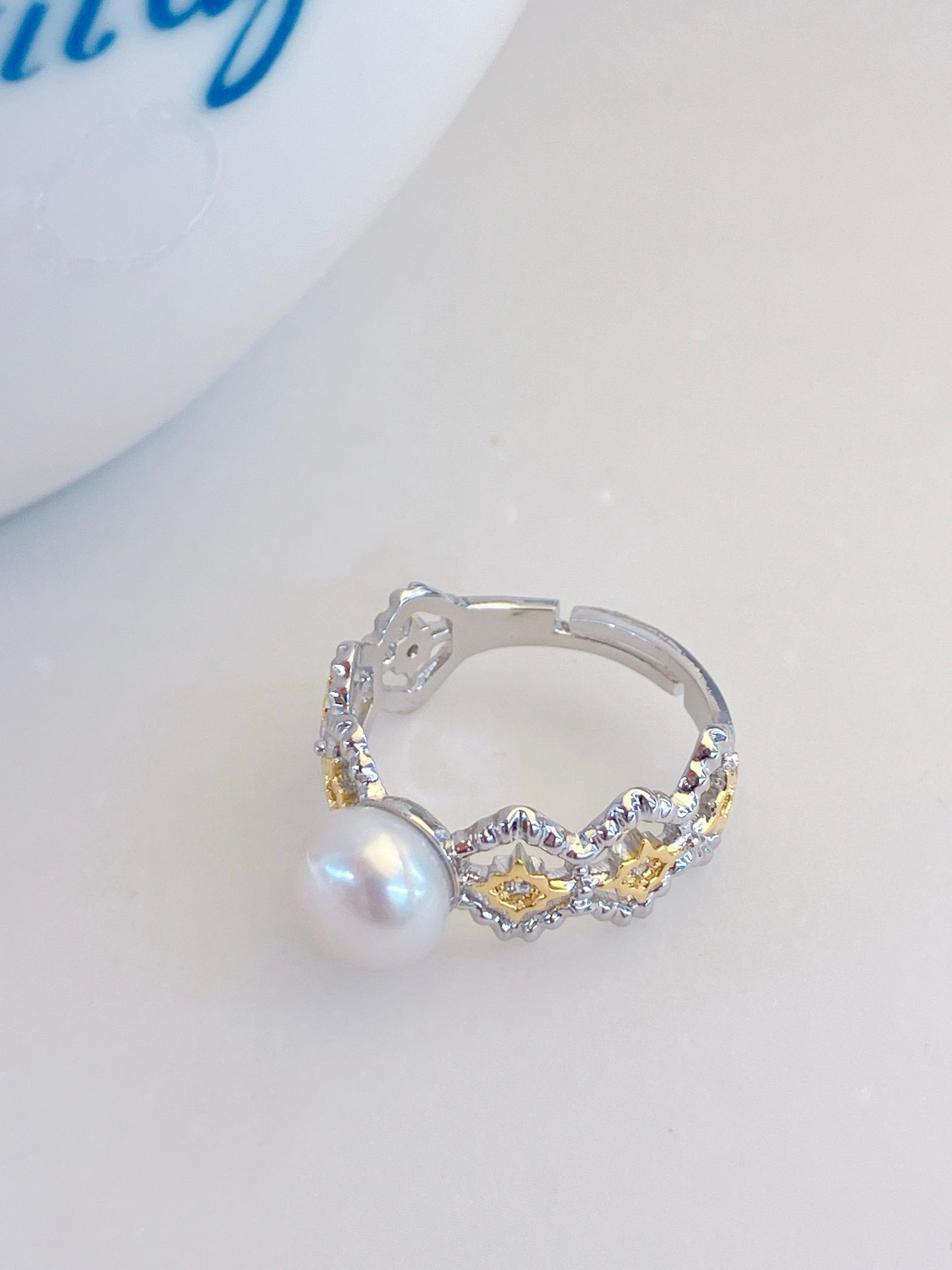Adjustable gold open ring with geometric cut-out design and freshwater pearl