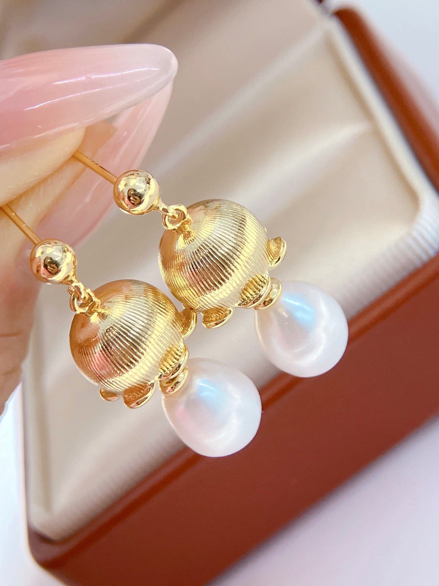 Close-up of Chinese-style lily of the valley pearl drop earrings
Pearl earrings with bellflower and silver drop design