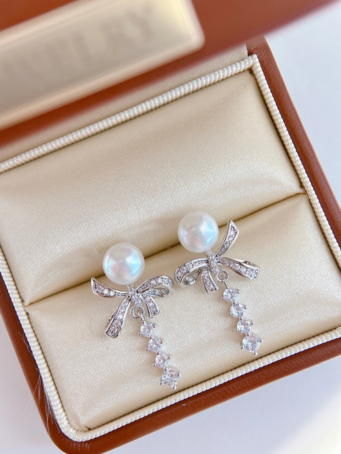 Model wearing silk ribbon bow pearl stud earrings
Close-up of freshwater pearl bow stud earrings