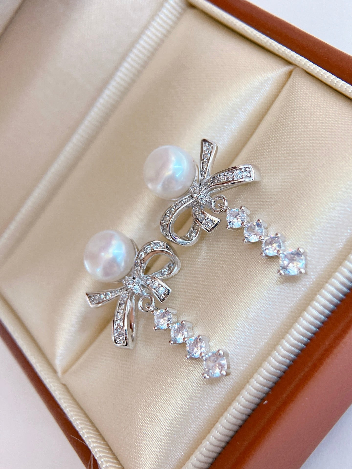 Model wearing silk ribbon bow pearl stud earrings
Close-up of freshwater pearl bow stud earrings