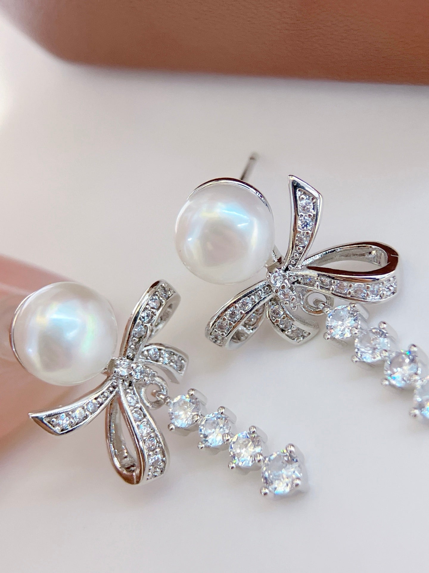 Model wearing silk ribbon bow pearl stud earrings
Close-up of freshwater pearl bow stud earrings