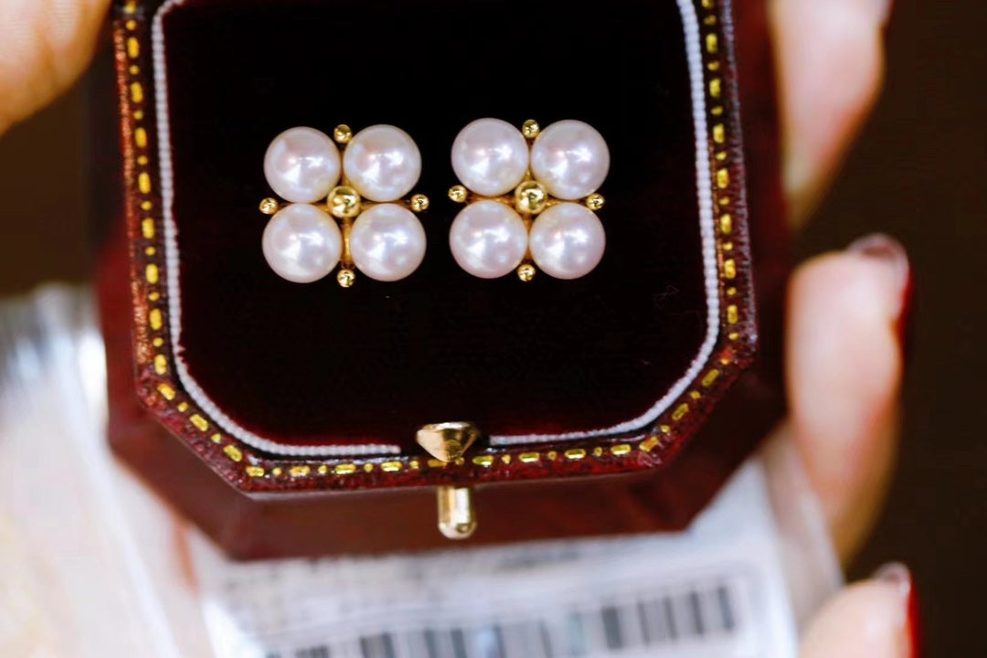 Close-up of four-leaf clover earrings with small freshwater pearls