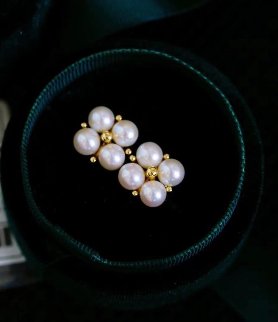 Close-up of four-leaf clover earrings with small freshwater pearls