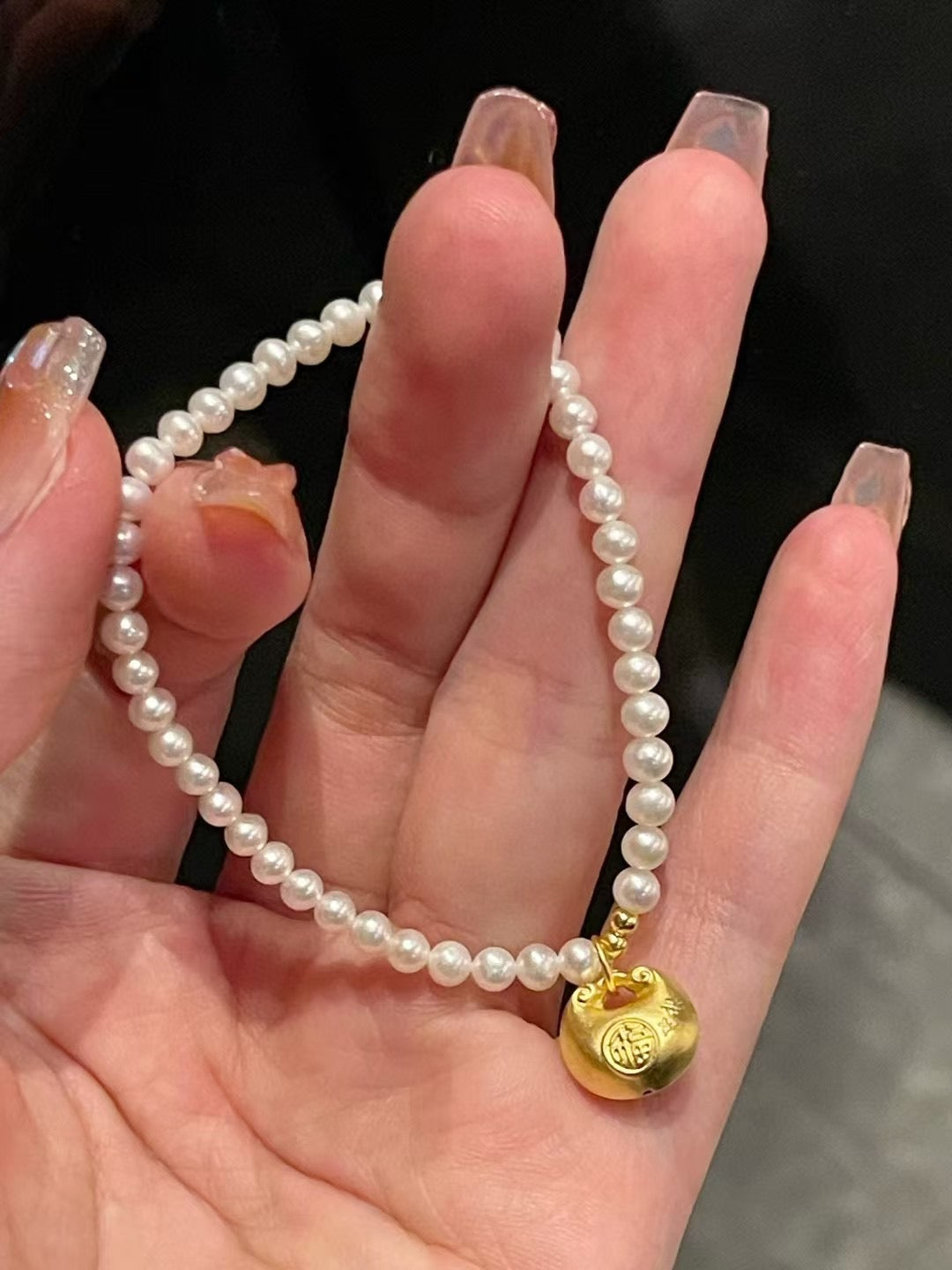 Lucky gold charm pearl bracelet with 3-4mm freshwater pearls and a fortune pouch bead on stretch cord, approx. 17cm length