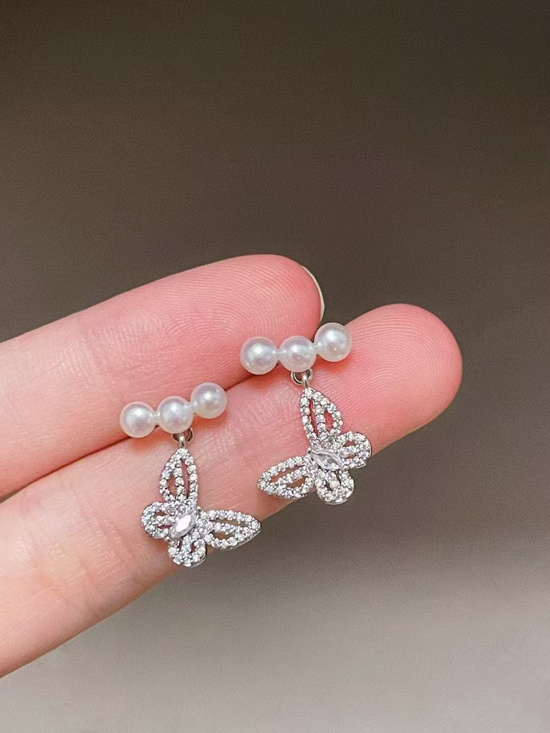 Elegant butterfly-shaped pearl earrings with 4–5mm freshwater pearls and silver ear posts