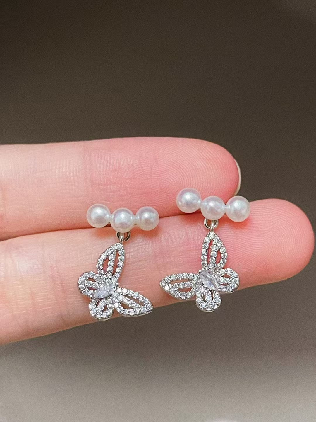 Elegant butterfly-shaped pearl earrings with 4–5mm freshwater pearls and silver ear posts