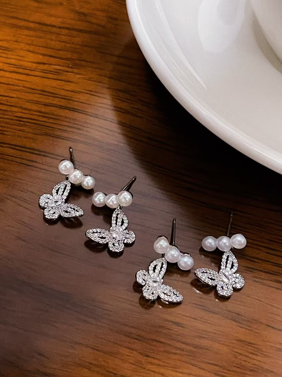 Elegant butterfly-shaped pearl earrings with 4–5mm freshwater pearls and silver ear posts