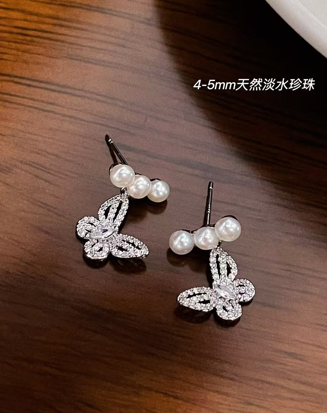Elegant butterfly-shaped pearl earrings with 4–5mm freshwater pearls and silver ear posts