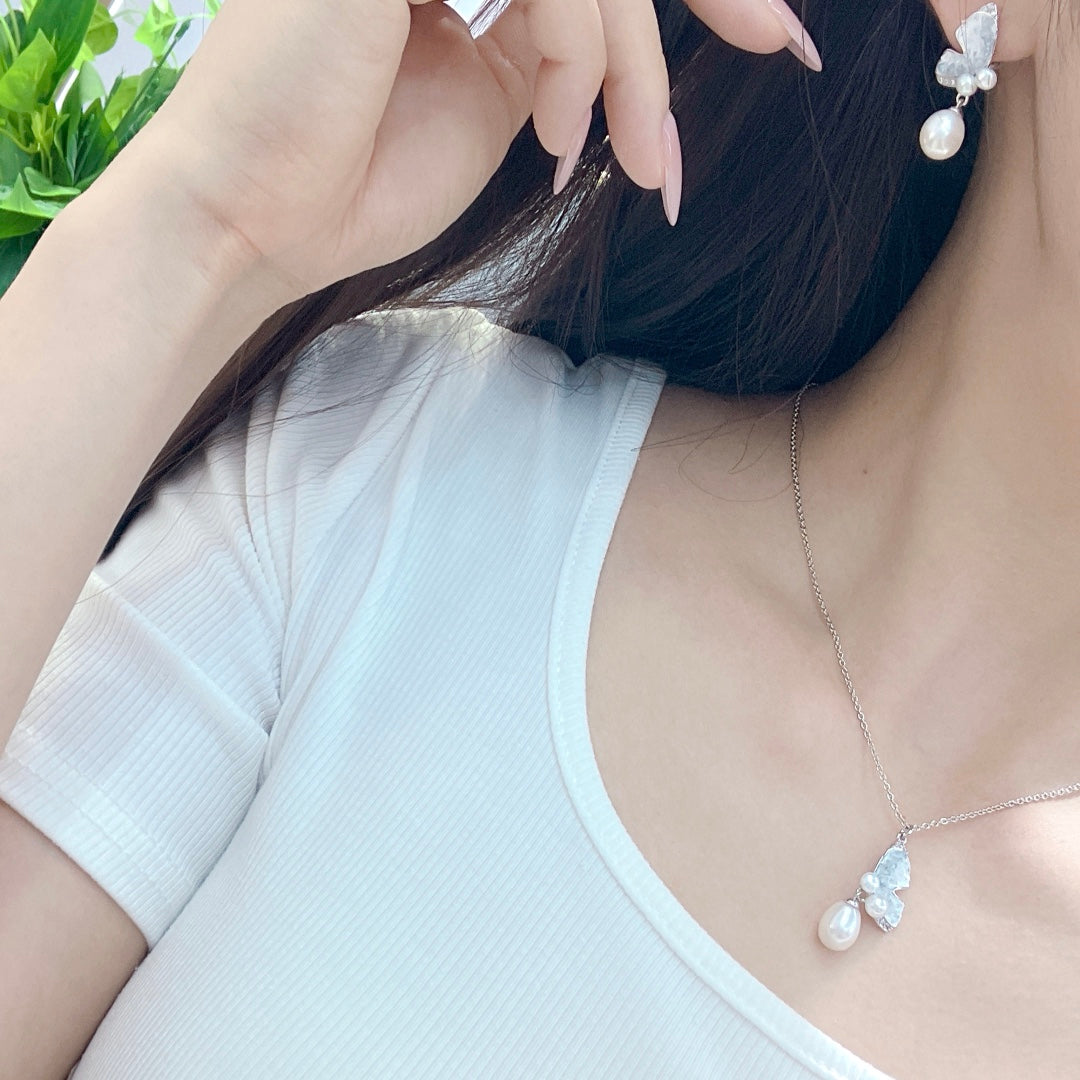 Model wearing modern oriental butterfly pearl necklace and matching earrings set