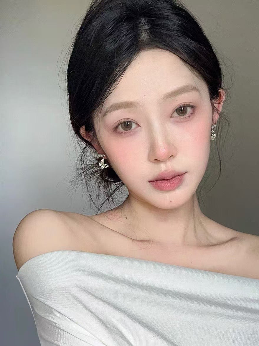 Model wearing elegant butterfly pearl stud earrings