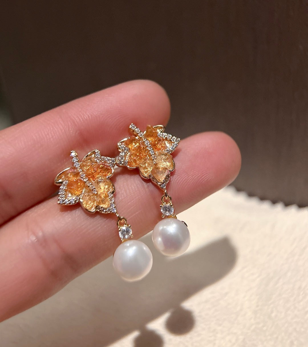 Close-up of crystal maple leaf with 7–8mm pearl and 925 silver ear post