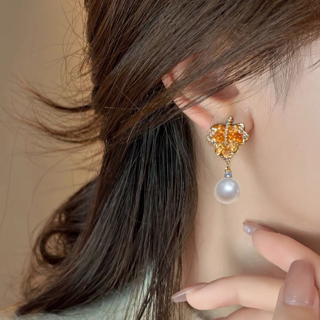 Model wearing red maple leaf pearl earrings from Hong Kong designer