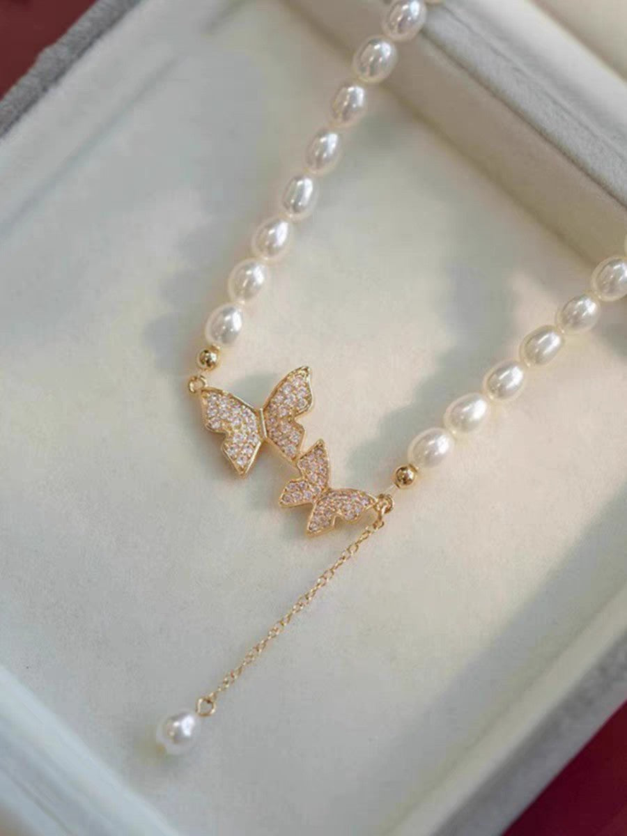 Close-up of butterfly charm with 4–5mm rice pearls