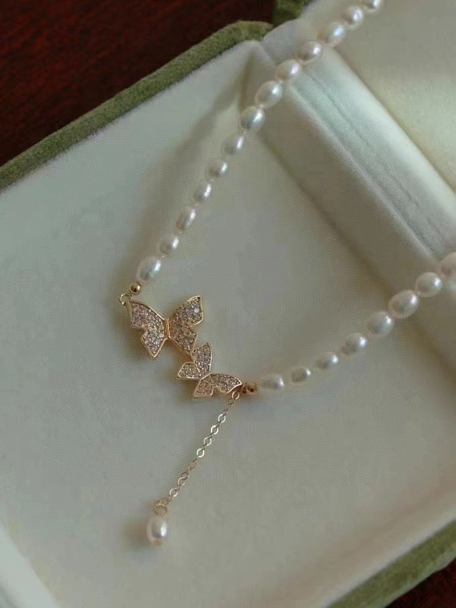 Close-up of butterfly charm with 4–5mm rice pearls