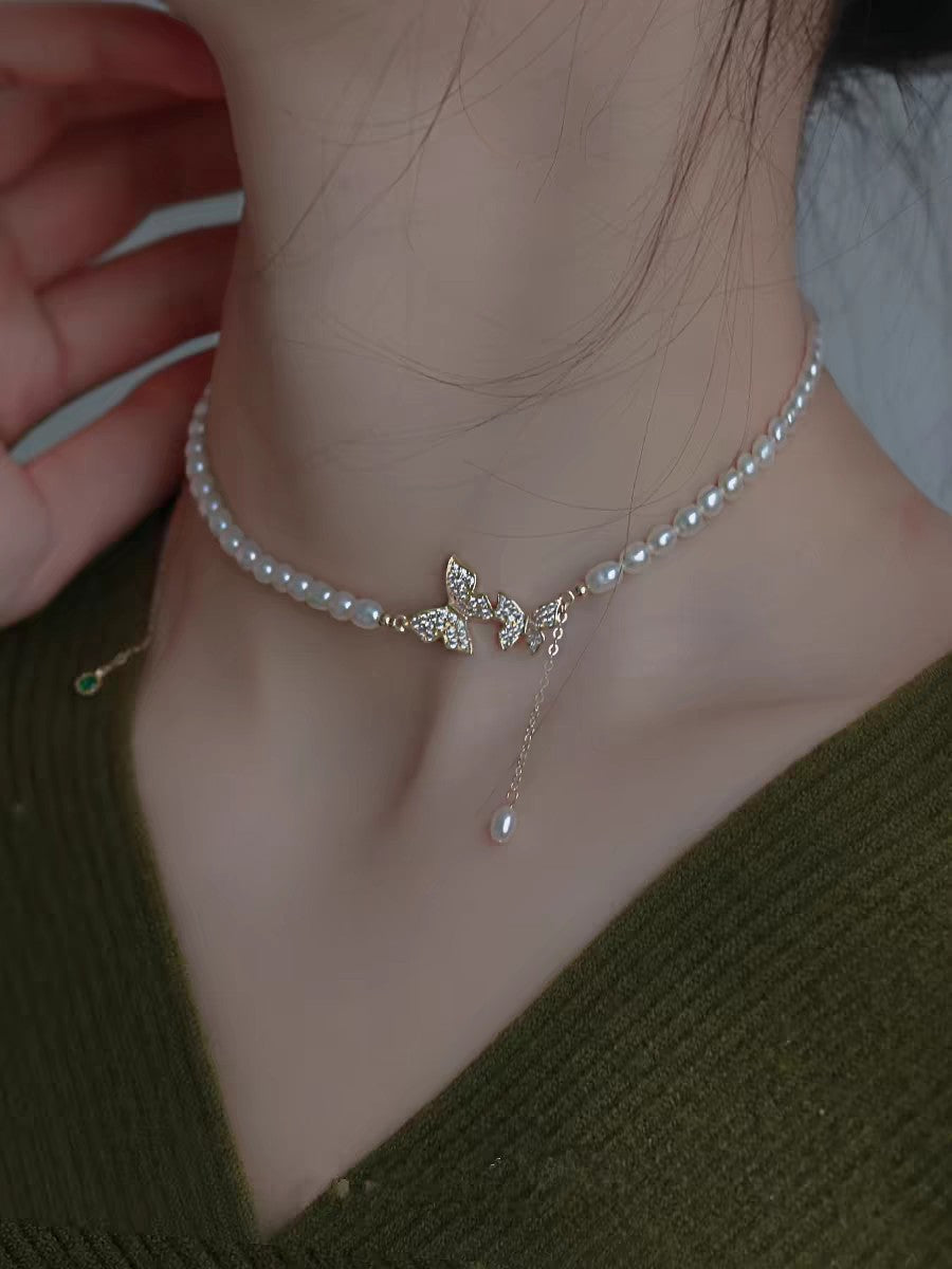 Model wearing spring-inspired butterfly pearl choker