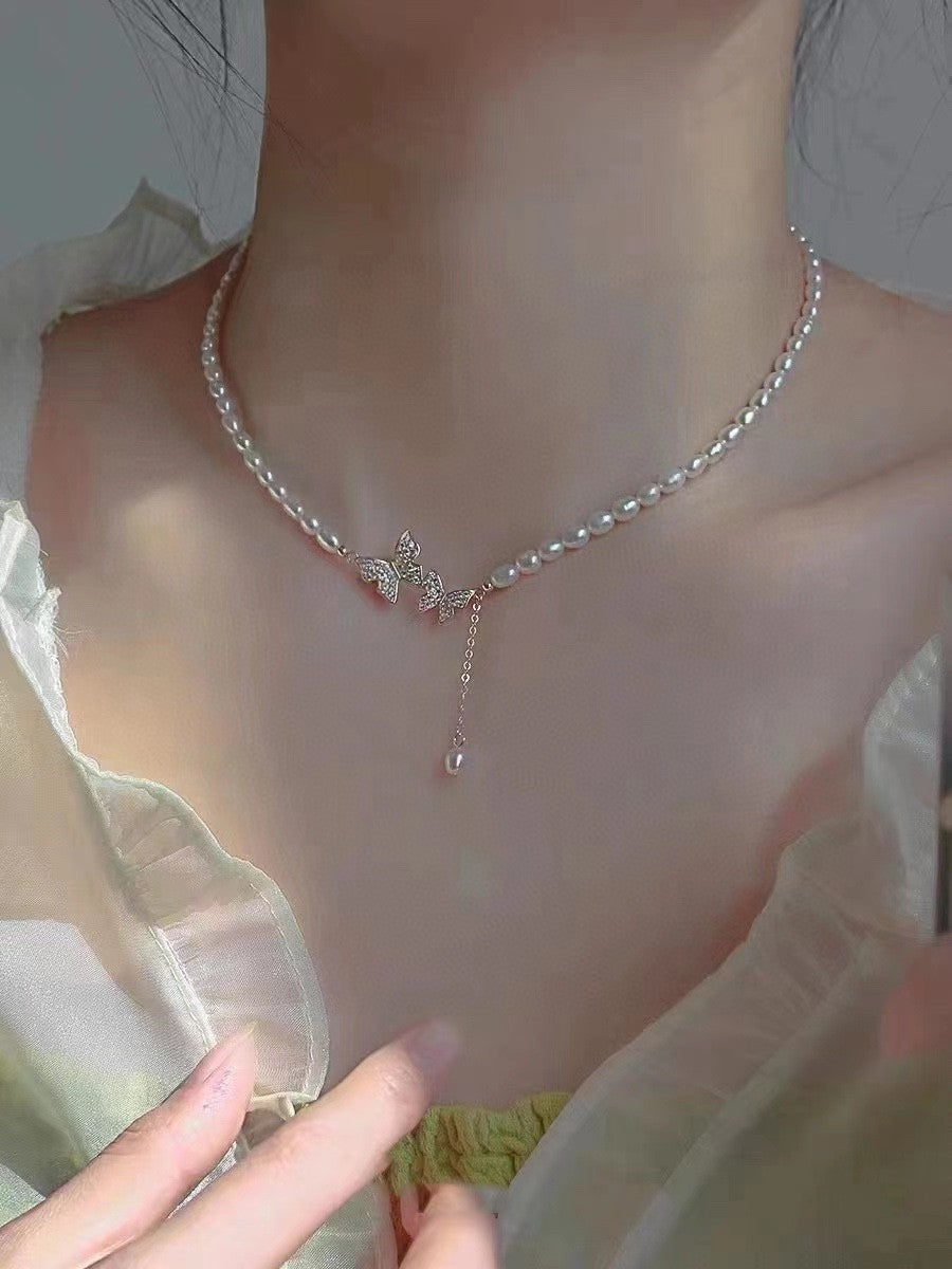 Model wearing spring-inspired butterfly pearl choker