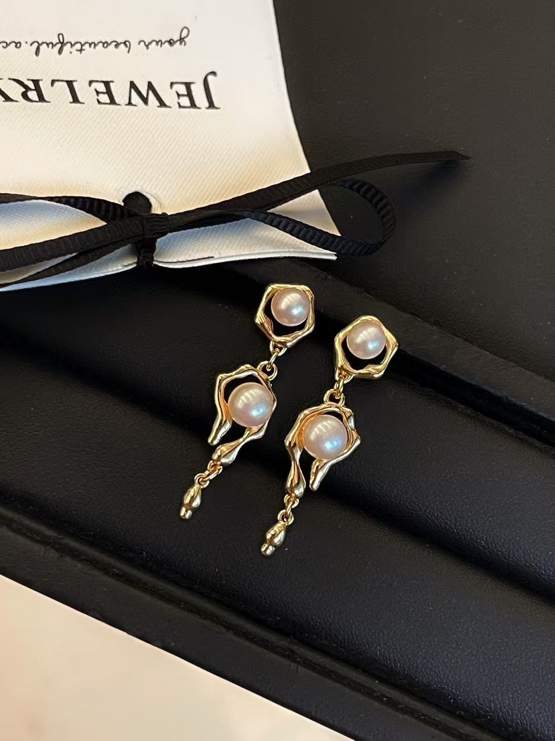 Molten metal pearl stud earrings with 5–6mm freshwater pearls on white background