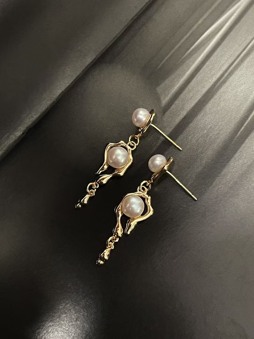 Molten metal pearl stud earrings with 5–6mm freshwater pearls on white background