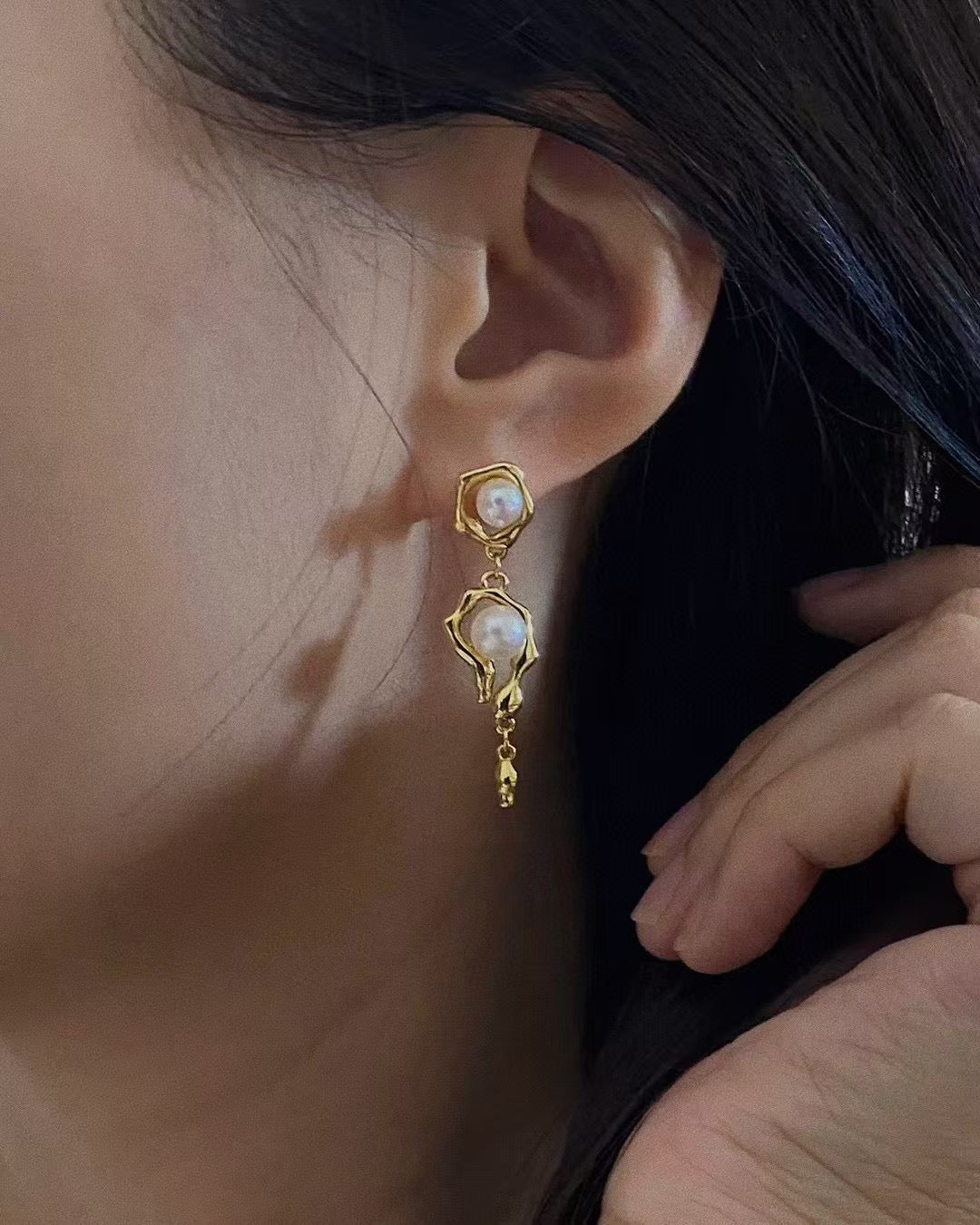 Model wearing sculptural molten pearl stud earrings