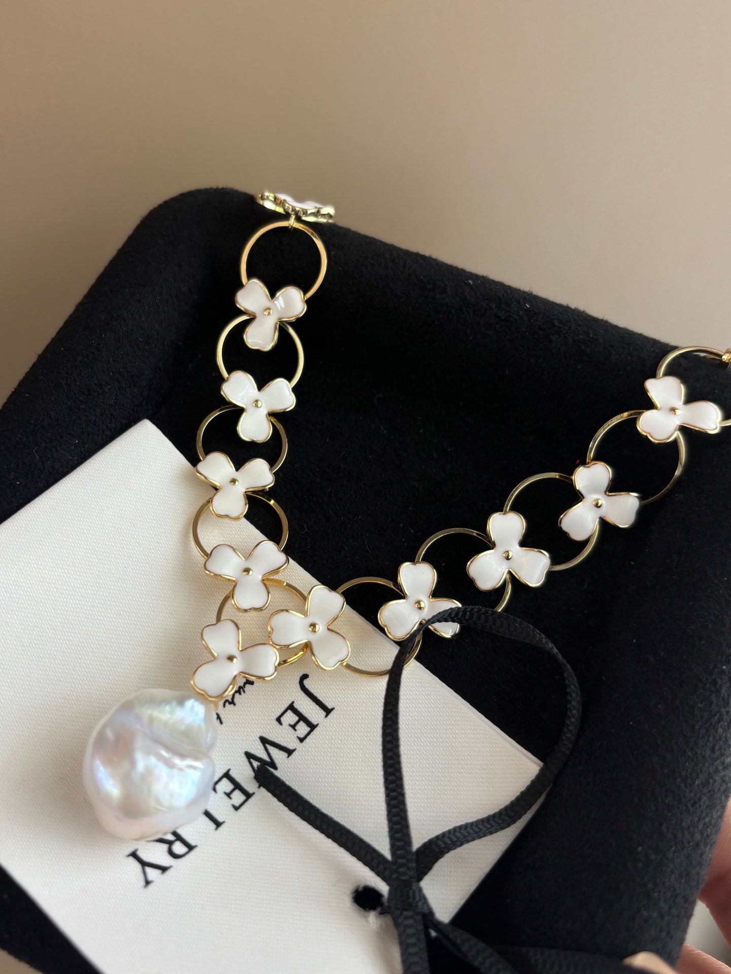 Close-up of irregular baroque pearls and clover charm