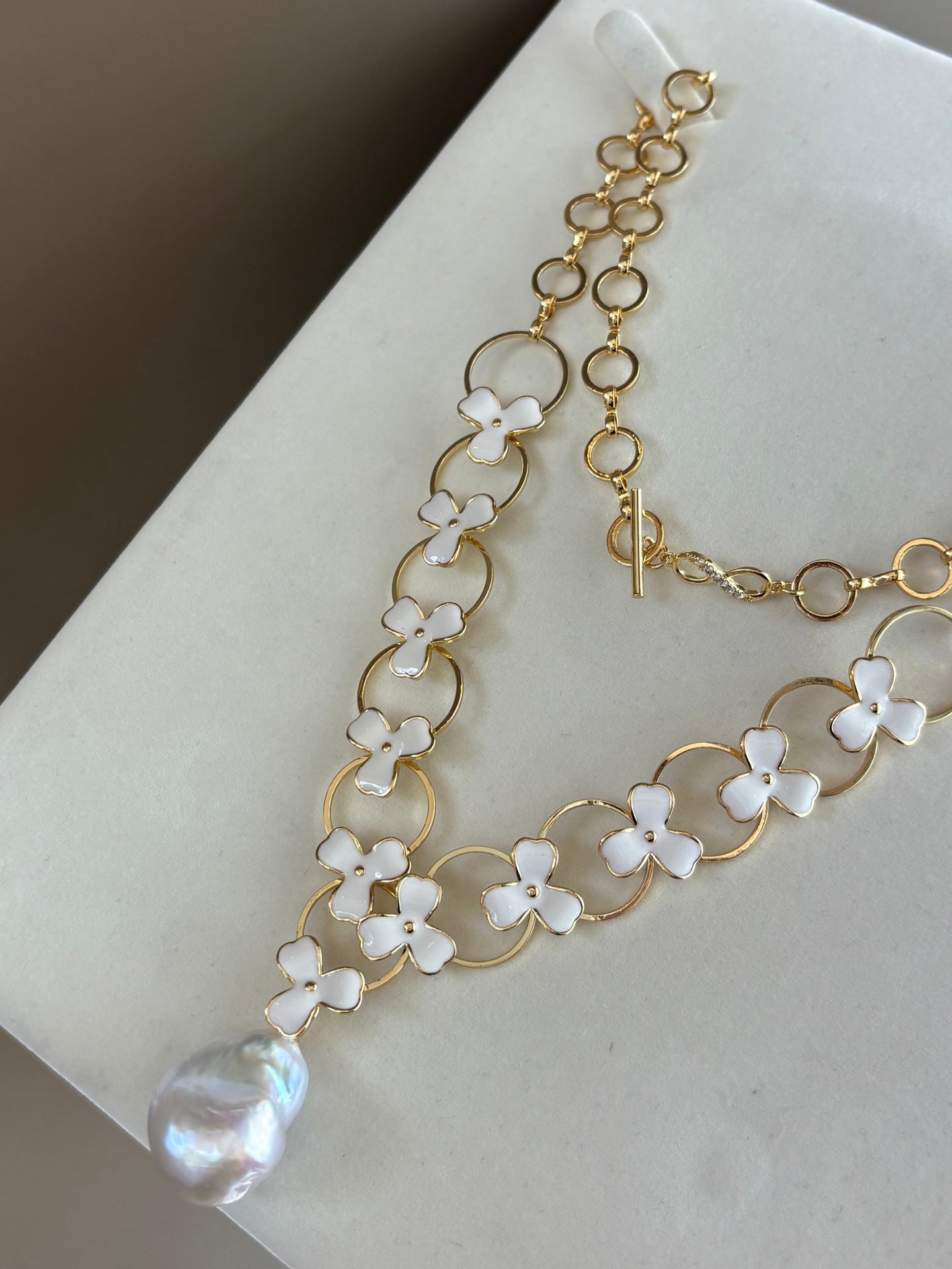 Close-up of irregular baroque pearls and clover charm