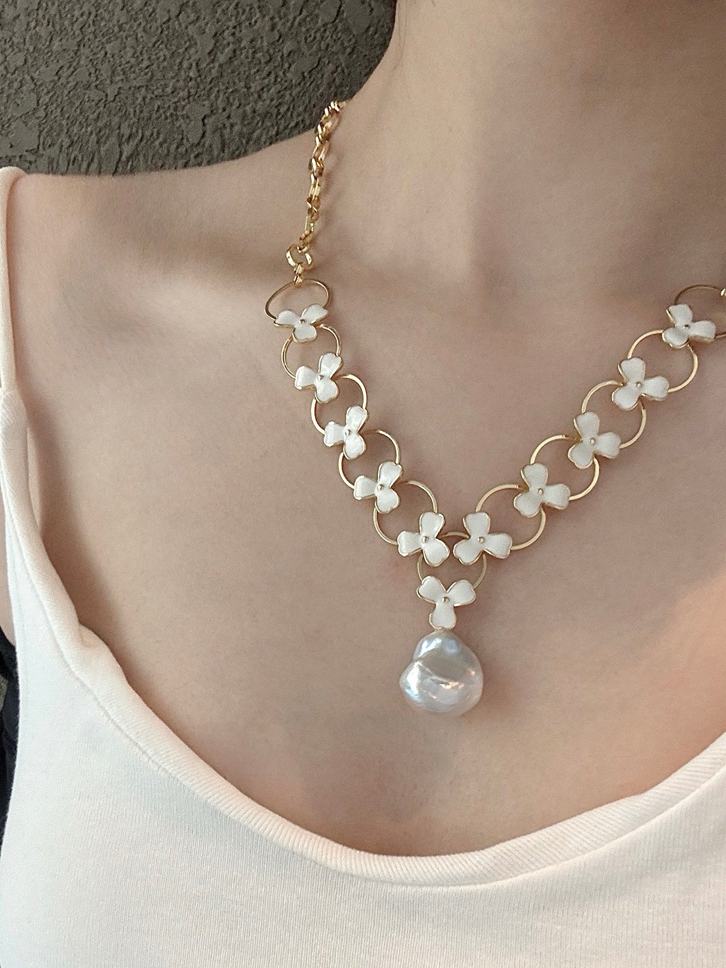 Model wearing double-layer pearl necklace with floral design