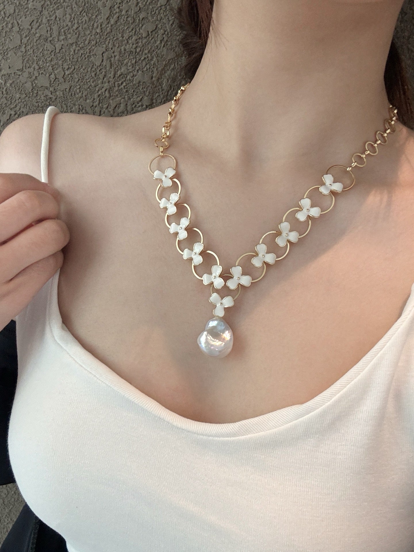 Model wearing double-layer pearl necklace with floral design