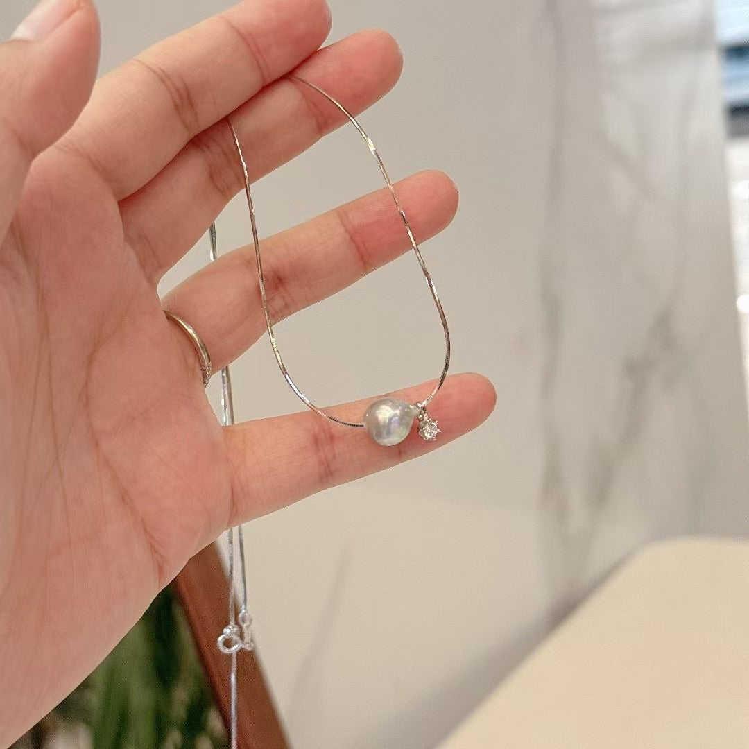 Close-up of 8–9mm aurora pearl in minimal pendant setting