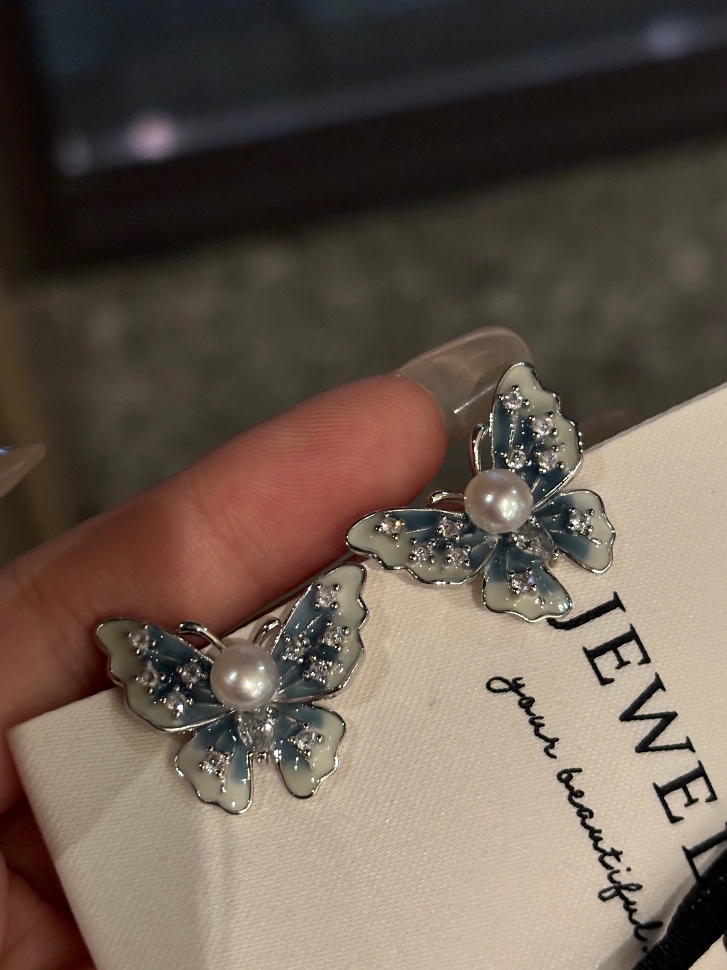 Close-up of blue butterfly wings with freshwater pearl drop